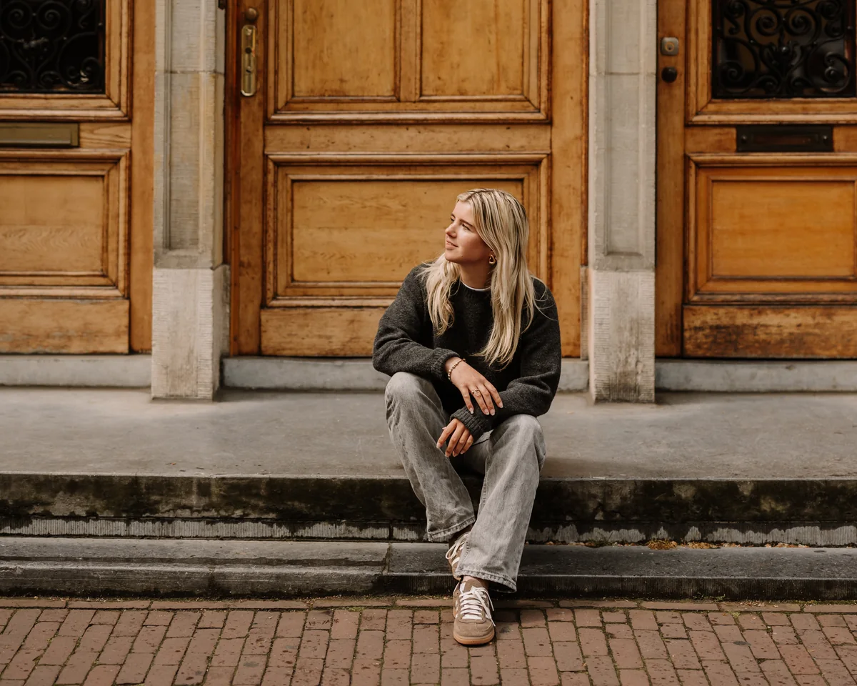 Lisa, buying agent in Amsterdam, on the steps by an Amsterdam front door