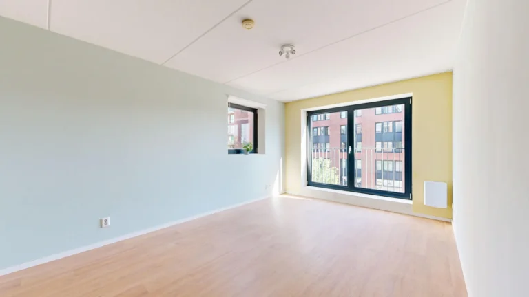 Lege, lichte kamer met laminaatvloer, klaar voor de oplevering