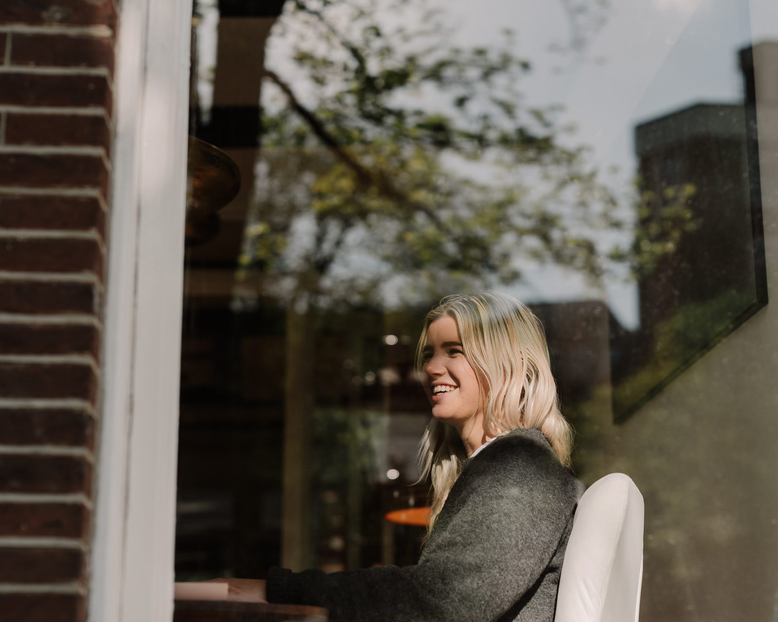 Lisa van Makelaar in Amsterdam kijkt naar buiten vanuit het kantoor