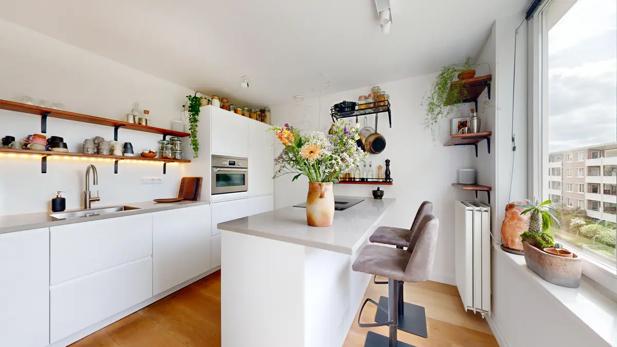 Lichte keuken met kookeiland, open planken en uitzicht naar buiten