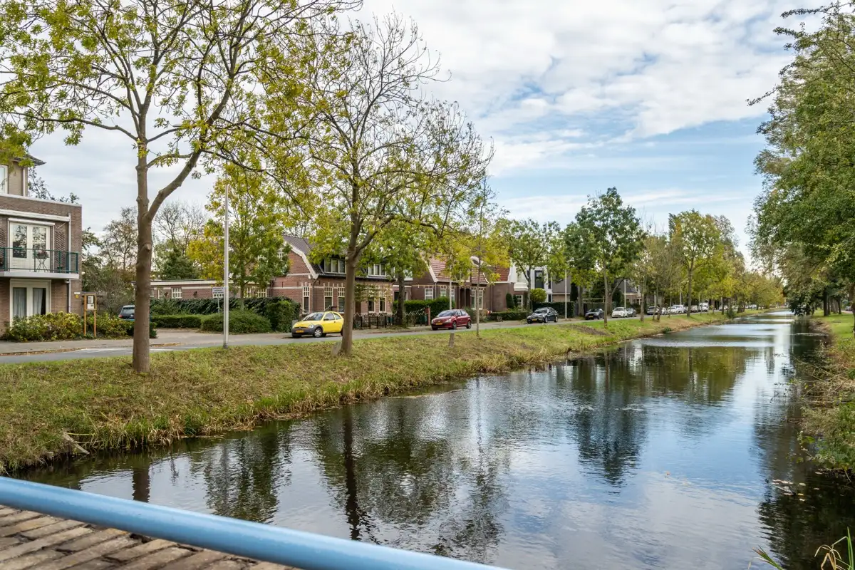 Water lined with trees and a row of houses in Amstelveen, close to the Veenendaalplein