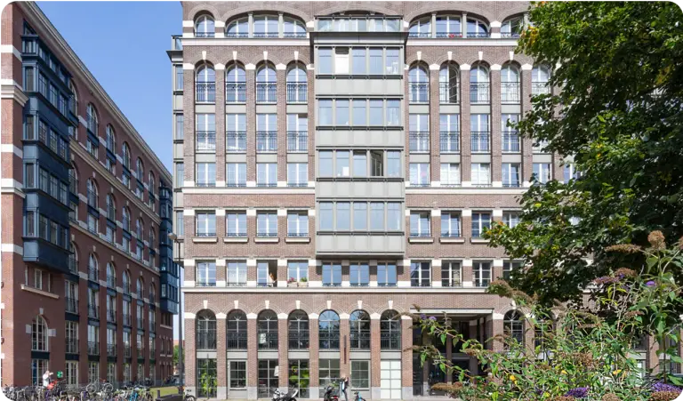 Groot bakstenen appartementengebouw met hoge ramen in Amsterdam