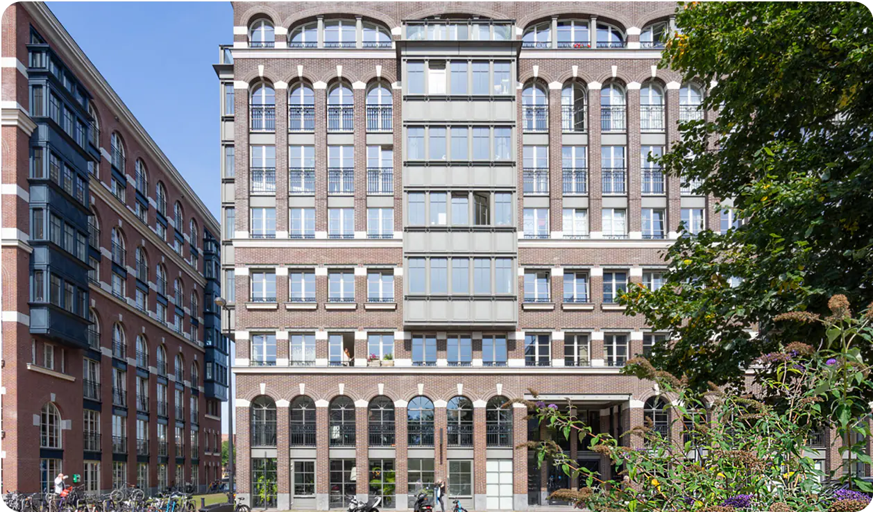 Groot bakstenen appartementengebouw met hoge ramen in Amsterdam