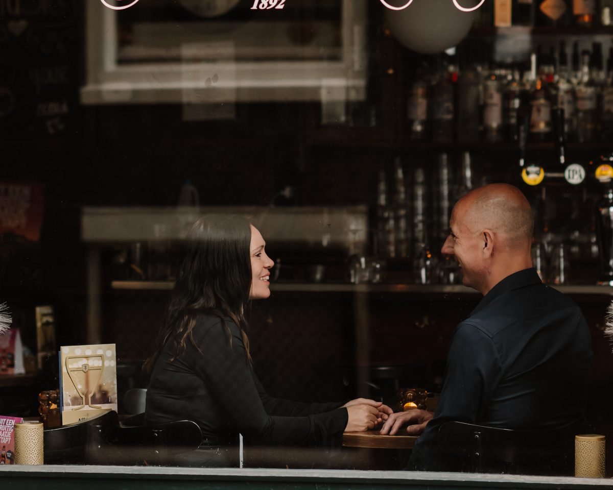 Micha en Hadewij in gesprek aan een tafeltje in een café